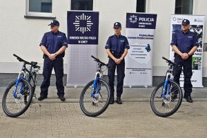 Trójka policjantów stoi obok policyjnych rowerów.