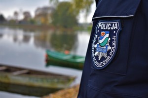 policyjna naszywka na przedramieniu policjanta a w tle rzeka