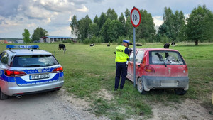 radiowóz, policjant, samochód osobowy, który najechał na znak drogowy