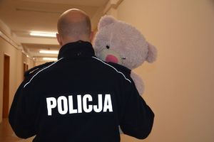 policjant niosący pluszowego misia